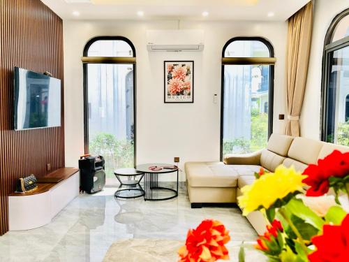 - un salon avec un canapé et une table dans l'établissement V3E02 Dahlia villa - khu nghỉ dưỡng Sonasea Vân Đồn, à Cái Rồng