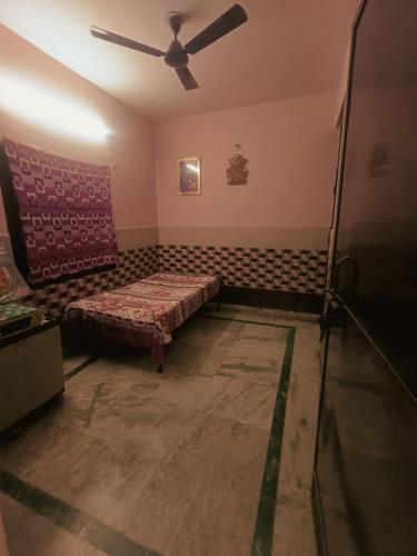 a room with a bed and a ceiling fan at Abhay gupta rental in Ghaziabad