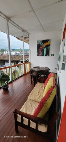 a bed in a room with a table on a deck at Hotel Arte Santa Rosa in Santa Rosa de Cabal