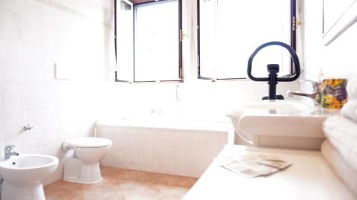 a bathroom with a sink and a toilet and a window at L' appartamento sul Naviglio in Milan