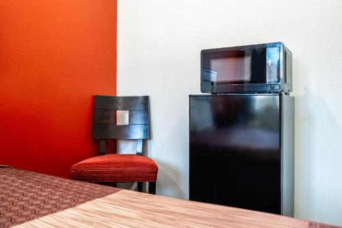 a black refrigerator with a tv on top of it at Bell Manor Motel in Bell