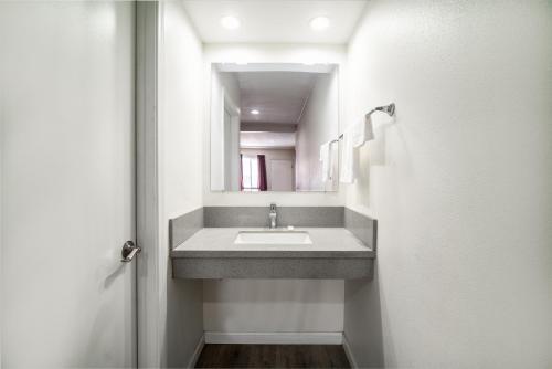 a bathroom with a sink and a mirror at Bell Manor Motel in Bell