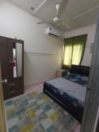 sypialnia z łóżkiem, drzwiami i oknem w obiekcie Rizki Homestay w mieście Nibung Tebal