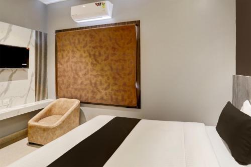 a bedroom with a bed and a chair and a window at OYO The Opulent Hotels And Resorts in Bhubaneshwar