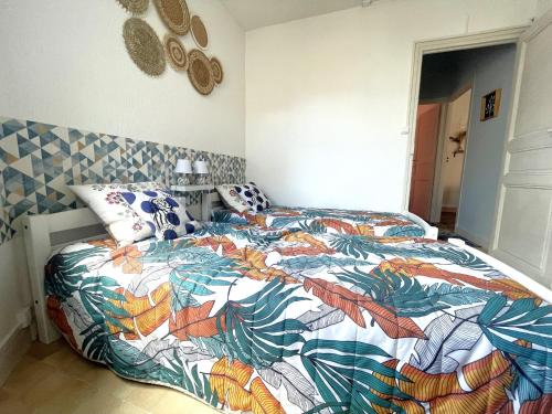 um quarto com uma cama com um edredão colorido em Appartement Banyuls-sur-Mer, 3 pièces, 4 personnes - FR-1-309-380 em Banyuls-sur-Mer