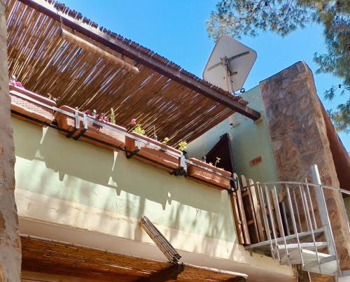 un balcone di una casa con TV satellitare di DomuNosta Pinus Village a Santa Margherita di Pula
