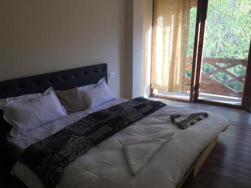 een groot bed in een kamer met een groot raam bij Gonay Manor in Leh