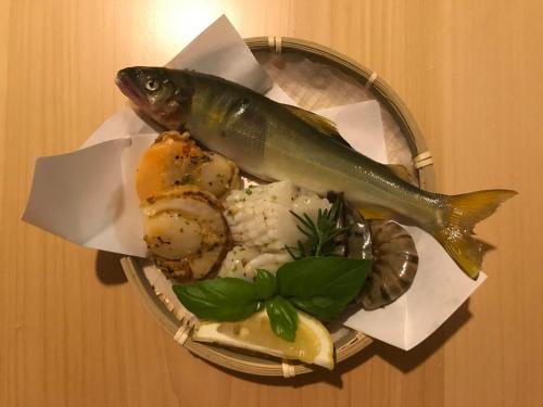 a plate of food with a fish on it at Myoko Forest Lodge in Myoko