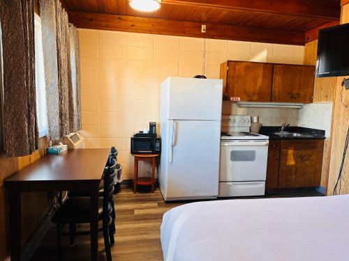 a kitchen with a white refrigerator and a table at Anchor Inn Motel by Loyalty in Blaine