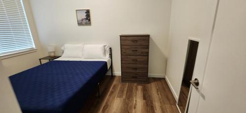 a small bedroom with a bed and a dresser at Urban Living: Stylish Apts in the Heart of Tacoma in Tacoma