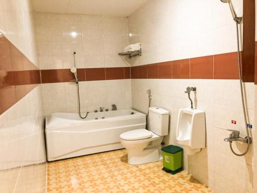 a bathroom with a tub and a toilet and a sink at Memories Hotel in Bảo Lộc