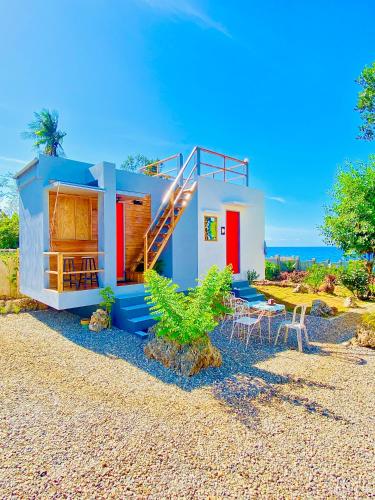 a house on the beach with a table and chairs at Tiny House's Seafront Room in Camotes Island in Esperanza
