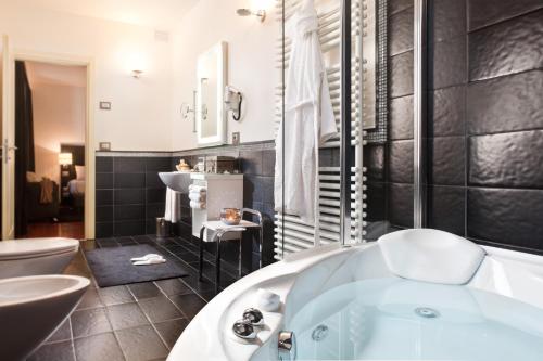 a bathroom with a tub and a toilet and a sink at Al Tezzon Hotel in Camposampiero