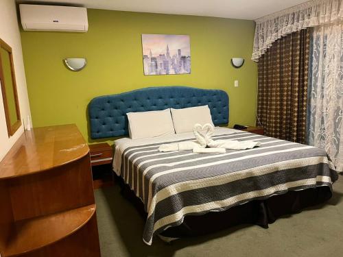 a bedroom with a bed with a blue head board at Hotel Libertad Pacasmayo in Pacasmayo