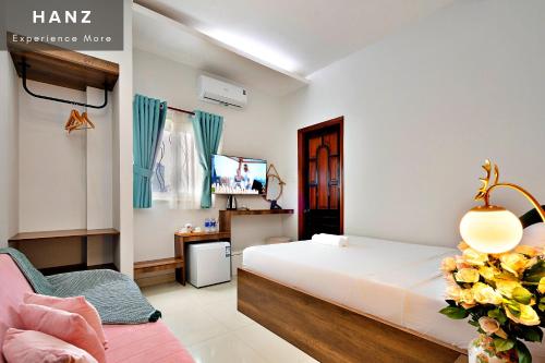 胡志明市的住宿－HANZ Vivianne Hotel，一间卧室配有一张床、一把椅子和电视。