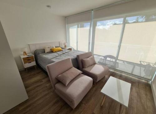 um quarto com uma cama, um sofá e uma mesa em Proamar em Punta del Este