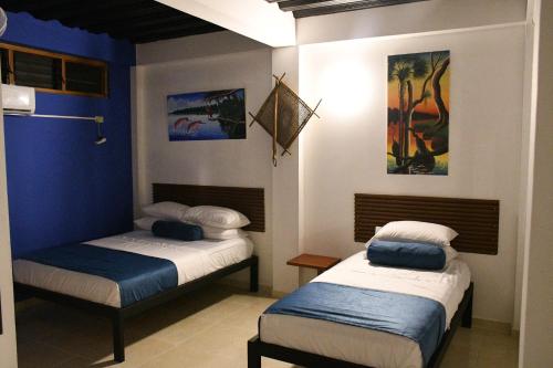 two beds in a room with blue walls at Cruz Roja - Turismo Solimões in Leticia