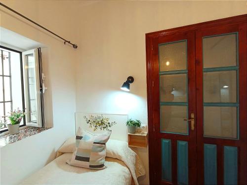 um quarto com uma porta e uma almofada numa cadeira em El Detalle em Zahara de la Sierra