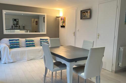 un salon avec une table, des chaises et un canapé dans l'établissement Small cottage for 4 people nestled in the heart of the dunes of Le Touquet, à Le Touquet-Paris-Plage