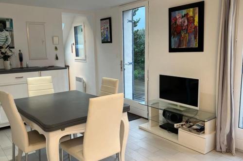 une cuisine et une salle à manger avec une table et une télévision dans l'établissement Small cottage for 4 people nestled in the heart of the dunes of Le Touquet, à Le Touquet-Paris-Plage