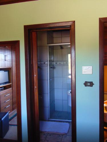 a bathroom with a shower and a glass door at Pousada Refúgio Akatu in Campos do Jordão