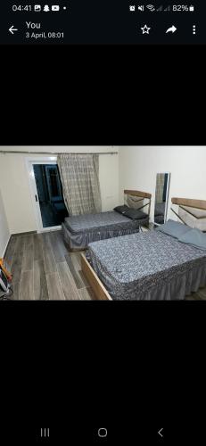 Una foto de un dormitorio con 2 camas en داون تاون العلمين الجديدة en ‘Ezbet `Abd el-Ḥamîd