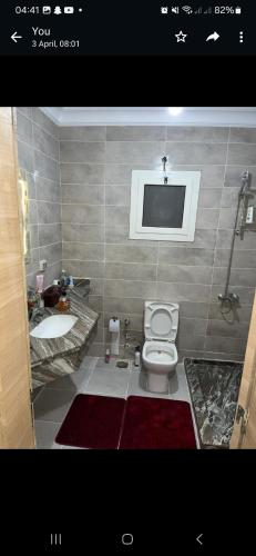 a bathroom with a toilet and a sink and a tv at داون تاون العلمين الجديدة in ‘Ezbet `Abd el-Ḥamîd