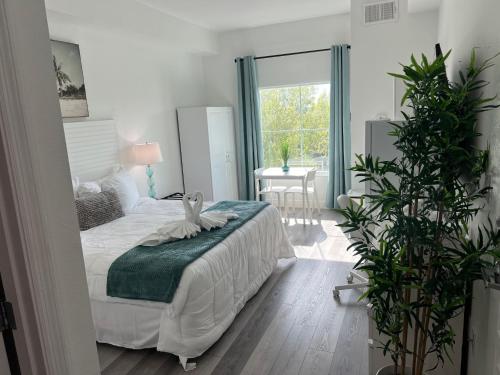 Dormitorio blanco con cama y mesa en King Bed Studio Near Disney, en Orlando