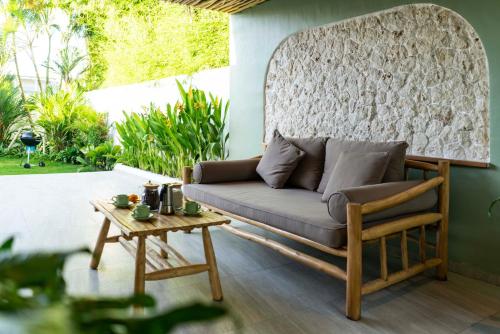 a couch on a patio with a table at Eden Garden Villa Canggu in Canggu