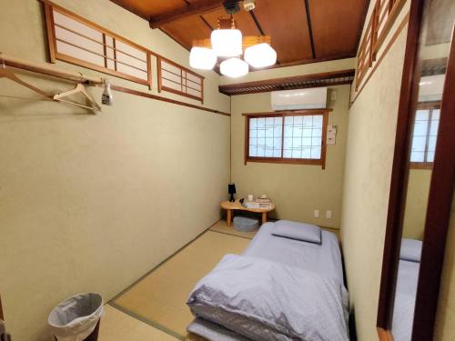um quarto de hospital com uma cama e uma mesa em Hostel Caranashi em Osaka