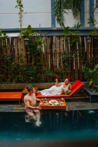 a woman laying on a raft in a swimming pool at Cambana Residence in Siem Reap
