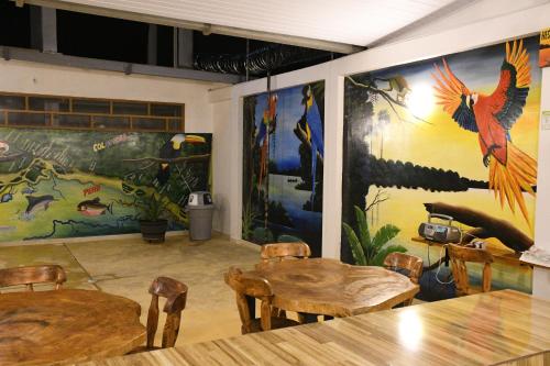 a room with tables and colorful paintings on the walls at Cruz Roja - Turismo Solimões in Leticia