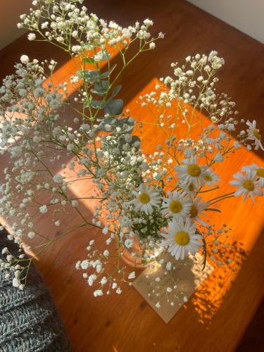 a wooden table with a vase of flowers on it at 本氣宿泊Honkiya in Hengchun