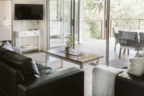 a living room with two couches and a coffee table at Kookaburra Cottage at On Burgum Pond in Maleny