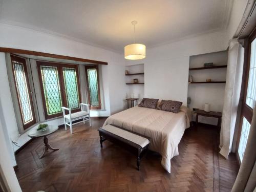 a bedroom with a bed and a bench in it at Casa amplia para 5 personas y cochera, a pasos del centro in La Plata