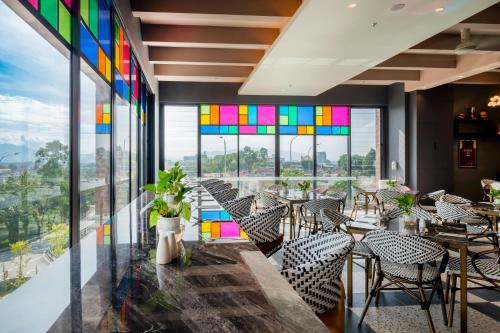 a restaurant with stained glass windows and tables and chairs at Arena Premier Hotel in Seremban