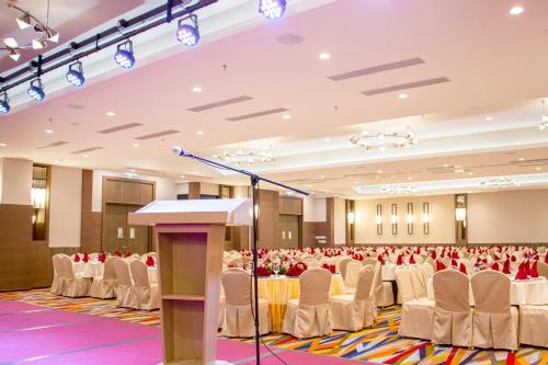 a conference room with rows of chairs and a podium at Arena Premier Hotel in Seremban