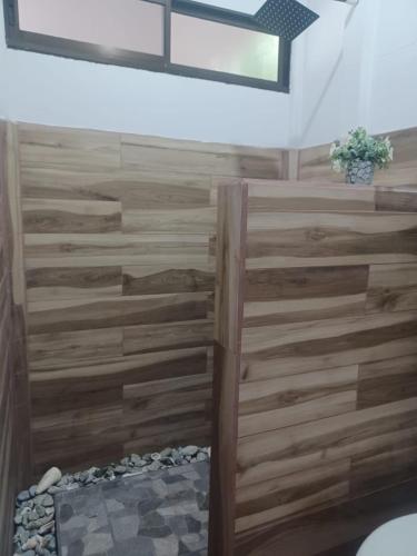 una parete rivestita in legno in una stanza con doccia di Mangata a Puerto Jiménez