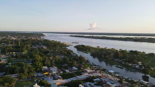 an aerial view of a river with houses and trees at Cruz Roja - Turismo Solimões in Leticia