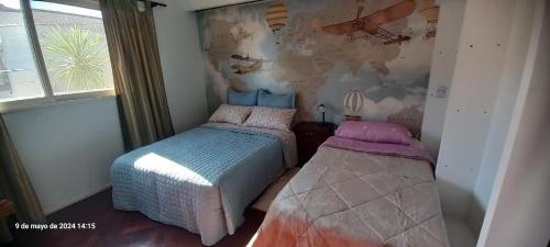 una camera con due letti e una mappa del mondo di VICTORIA bed and breakfast a Ezeiza