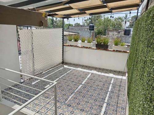 une terrasse avec des plantes en pot et une clôture dans l'établissement Loft Santa Rosa, à Apizaco
