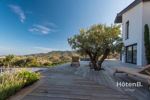 une passerelle en bois avec un banc et un arbre dans l'établissement Villa Blanca 5 Sea View and Mountain, à Banyuls-sur-Mer
