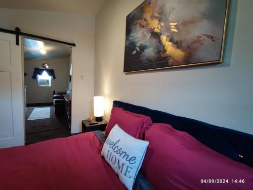 a living room with a red couch and a painting on the wall at Zen Haven 5- Close to Downtown Indy- Queen Bed in Indianapolis