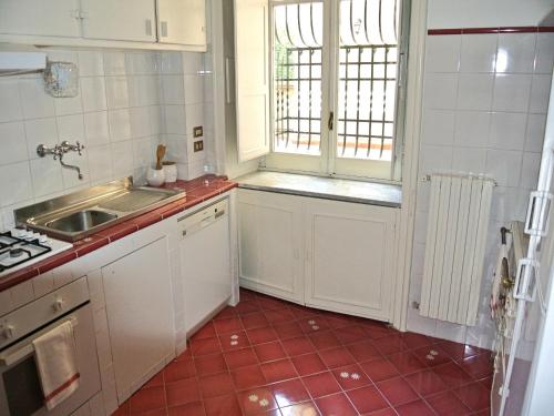 cocina con armarios blancos y suelo de baldosa roja en OS Garden - Maison de Charme, en Salerno