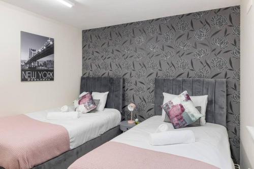 um quarto com duas camas e uma parede com flores em Charming 1-BR Flat in Prime North London Location em Londres