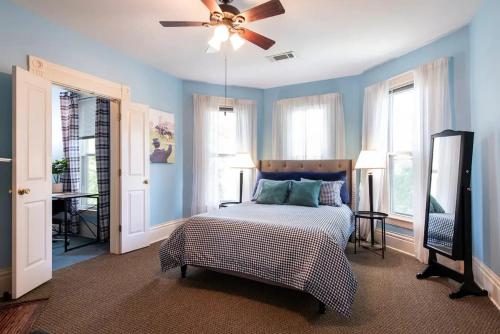 una camera da letto con pareti blu e un letto con ventilatore a soffitto di Spacious Historic House Near Louisville Sites a Louisville