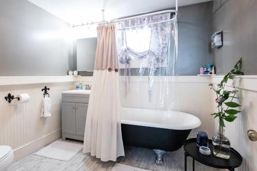 a bathroom with a tub and a shower curtain at Spacious Historic House Near Louisville Sites in Louisville