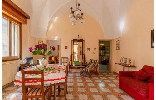 sala de estar con mesa y sofá rojo en Casa Vacanze Sant'Anna, en Parabita