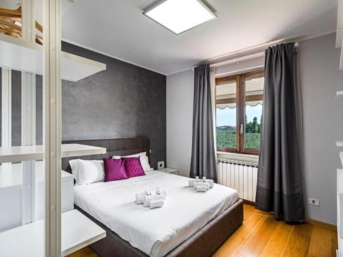 西爾米奧奈的住宿－Lugana Point Comfortable holiday residence，一间卧室配有带粉红色枕头的床和窗户。