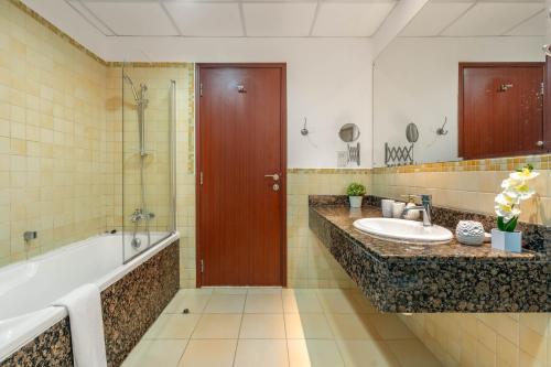 een badkamer met een bad, een wastafel en een douche bij MAJESTIC JBR - SEA VIEW - Jumeirah Beach Residence in Dubai